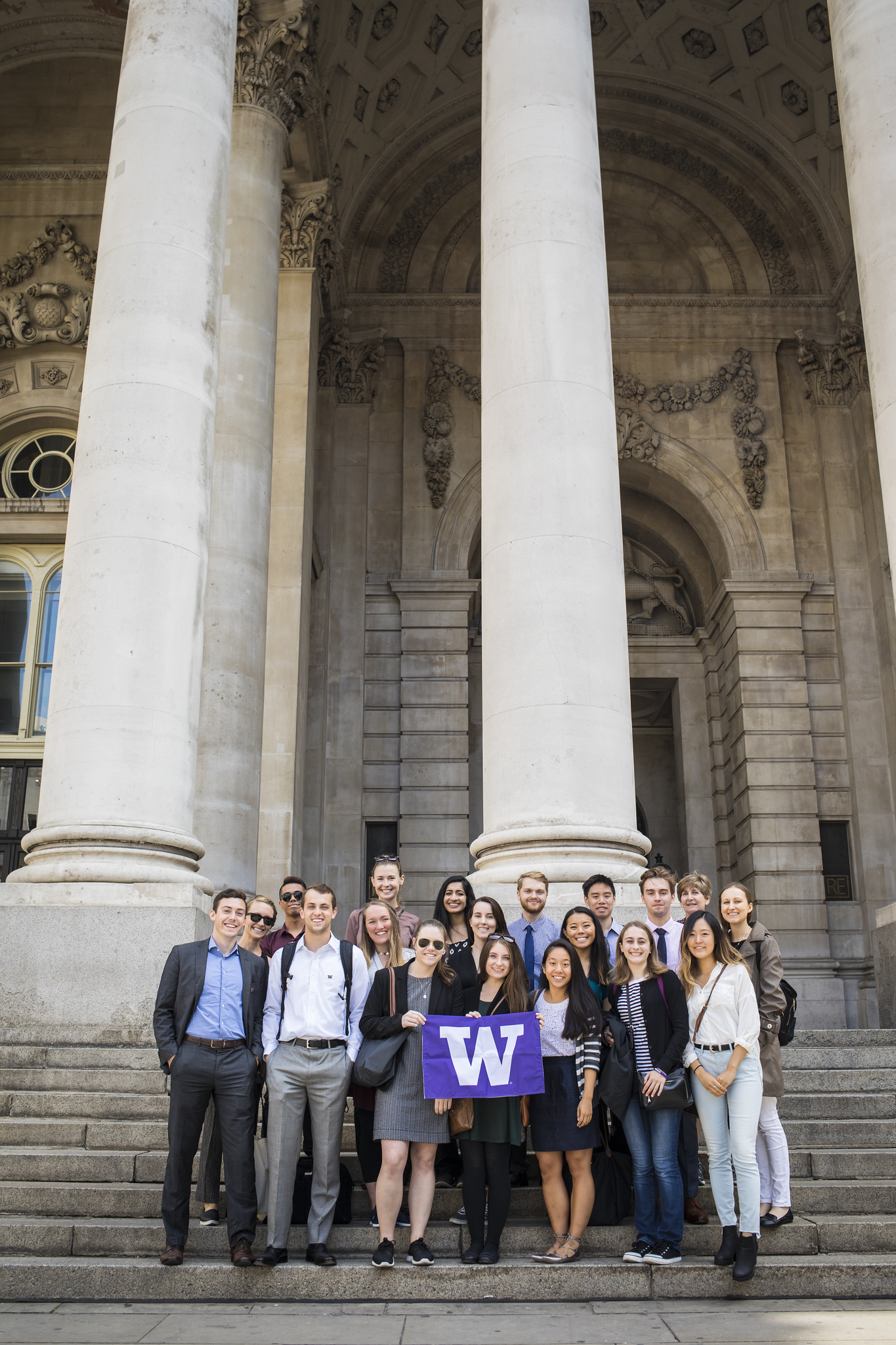 A student tour group holds up a W flag